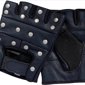 May include: A pair of fingerless black leather gloves featuring silver-toned metal studs across the knuckles and back of the hand. The gloves include black fabric panels between the fingers and a hook-and-loop closure strap at the wrist area.