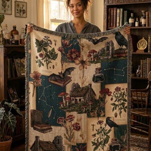 May include: A woven throw blanket featuring a patchwork design of botanical illustrations, stone cottages, bats, ravens, inkwells, books, and constellations in shades of cream, dark green, brown, and red with a fringed edge.