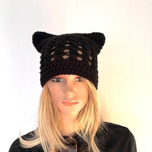 May include: Black crocheted beanie with cat ears. The beanie has a lacy pattern and is made with a soft yarn.