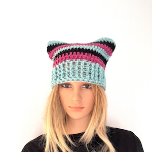 May include: A light blue, black and pink striped crochet beanie with ear flaps.