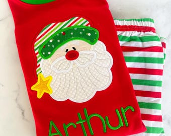 May include: Red and green striped pajamas with a Santa Claus applique and the name "Arthur" embroidered on the front.