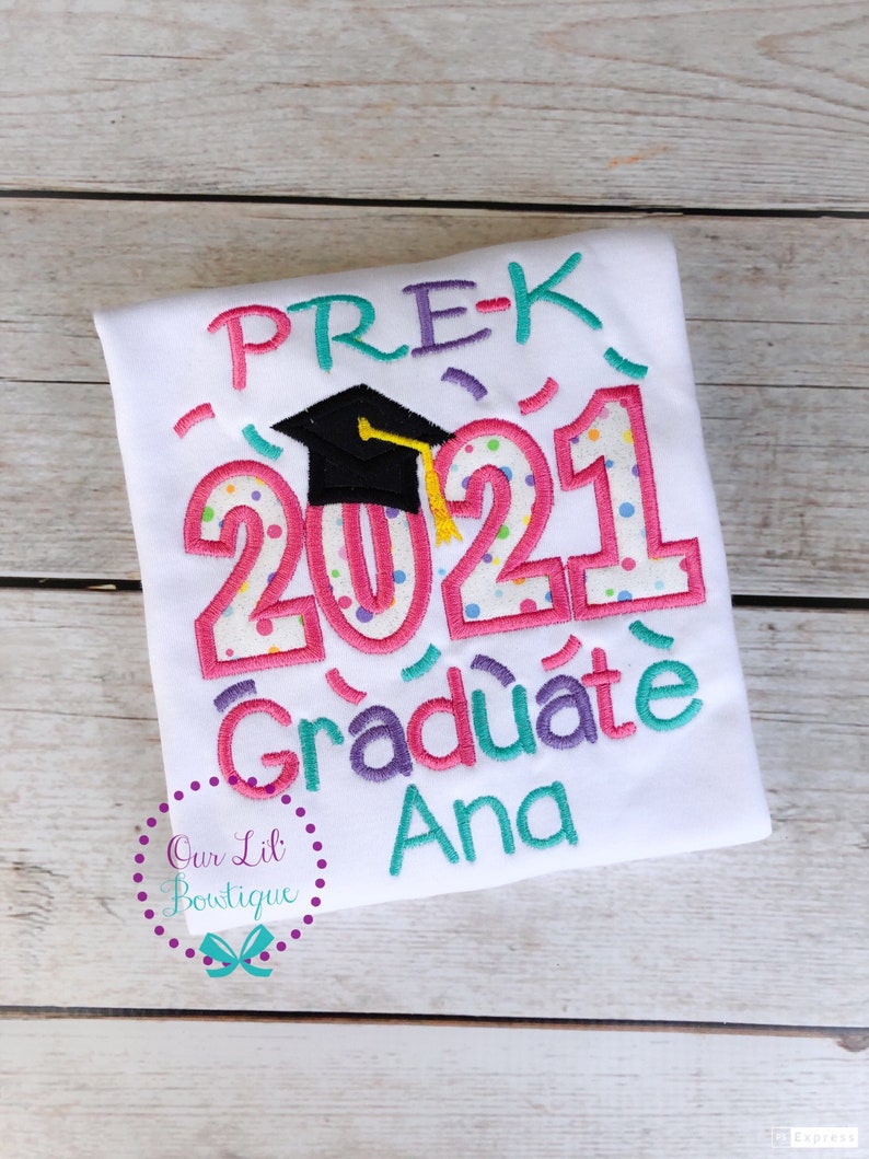 May include: White t-shirt with colorful embroidery that says "PRE-K 2021 Graduate Ana". The embroidery includes a graduation cap and confetti.