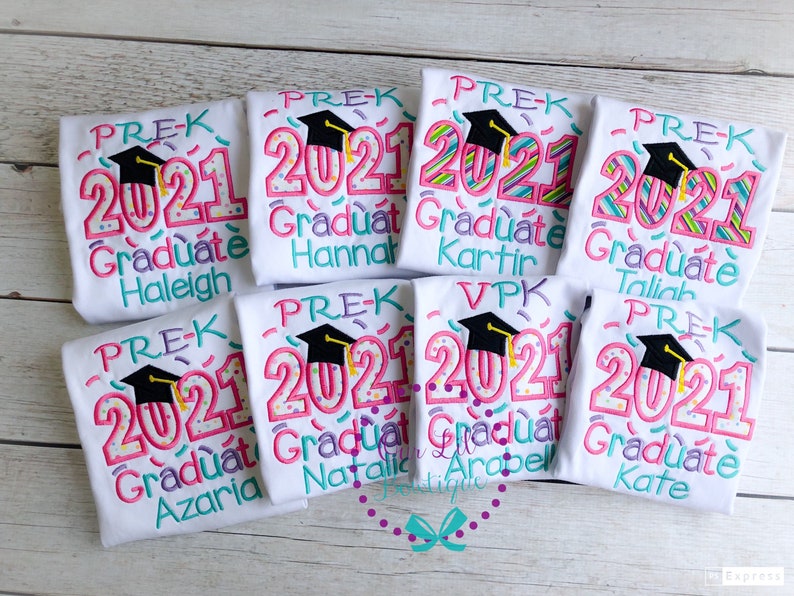 May include: Eight white t-shirts with colorful embroidered designs. Each shirt says "PRE-K 2021 Graduate" with a graduation cap and a different name underneath. The names are Haleigh, Hannah, Kartir, Taliah, Azaria, Natalie, Arobell, and Kate.