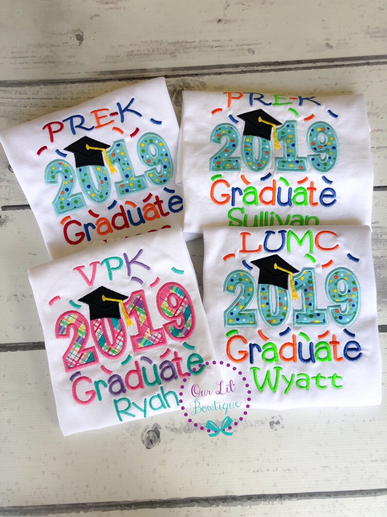 May include: Four white t-shirts with colorful embroidered designs for preschool graduation. The shirts feature the year 2019, a graduation cap, and the words "PREK Graduate", "VPK Graduate", "LUMC Graduate", and "Graduate".
