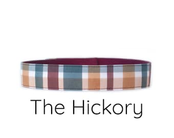 Może przedstawiać: Szyja dla psa w kratę w kolorze brązowym, beżowym i niebieskim z bordową podszewką. Pod szyją znajduje się napis "The Hickory".