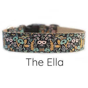 May include: A black dog collar with a floral pattern in shades of pink, green, and gold. The text "The Ella" is printed below the collar.