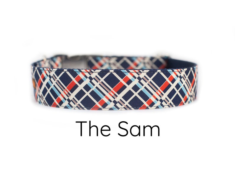 May include: A navy blue dog collar with a white, red, and blue plaid pattern. The text "The Sam" is printed below the collar.