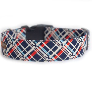 May include: A navy blue dog collar with a white, red, and blue plaid pattern.
