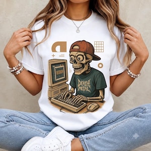 May include: A white t-shirt featuring a graphic of a skeleton wearing a brown baseball cap and a dark green t-shirt with the text "DEATH METAL" printed on it. The skeleton is typing on a computer keyboard in front of a vintage computer monitor.