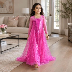 Könnte beinhalten: Ein bodenlanges Kleid in leuchtendem Pink mit langen, transparenten Ärmeln, einem mit Pailletten besetzten Oberteil und einem fließenden Rock mit dezentem Sternenmuster. Das Kleid hat einen Rundhalsausschnitt und eine weit ausgestellte Form.