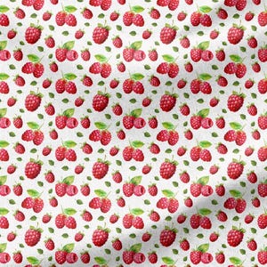 Op de afbeelding: Een witte stof met een herhalend patroon van rode frambozen met kleine groene blaadjes. Het ontwerp bestaat uit talloze individuele framboosillustraties die op een consistente, dichte en uniforme wijze over het oppervlak zijn verspreid.