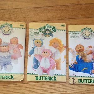 May include: Three Butterick sewing pattern envelopes for Cabbage Patch Kids Preemies clothes, numbered 6981, 3565, and 4331. Each envelope features illustrations of dolls wearing various outfits, including animal costumes and baby clothing sets.