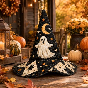 May include: A quilted witch hat in black fabric featuring a white ghost appliqué, a yellow crescent moon, and small orange stars. The hat has a wide brim with a geometric star pattern in black and cream, showcasing detailed stitching throughout.