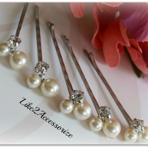May include: Set of five silver hair clips with a single rhinestone and two faux pearls on each clip.  The pearls are white and the rhinestones are clear.