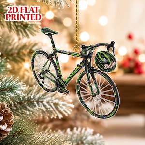 May include: A 2D flat printed Christmas tree ornament shaped like a road bicycle with a green and black frame, decorated with colorful string lights. A matching green and black helmet with the name Jonh printed in red is attached to the handlebars.
