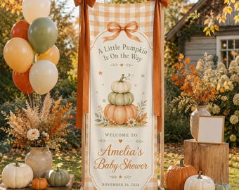 Puede incluir: Una pancarta vertical con un patrón de cuadros naranja claro que presenta una pila de tres calabazas, un gráfico de lazo y el texto A Little Pumpkin Is On the Way, Welcome To Amelia's Baby Shower, y la fecha November 16, 2026, atada con cintas naranjas.