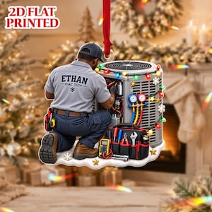 Op de afbeelding: Een plat 2D-bedrukt ornament met een HVAC-technicus in een grijs shirt met de tekst ETHAN HVAC TECH, knielend naast een airconditioningunit. De unit is versierd met kleurrijke kerstverlichting, sterren en sneeuwvlokken.
