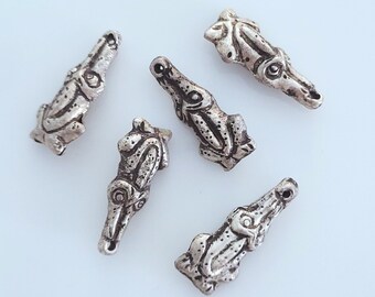 May include: Five silver alligator charm pendants with detailed carvings. The charms are on a white background.
