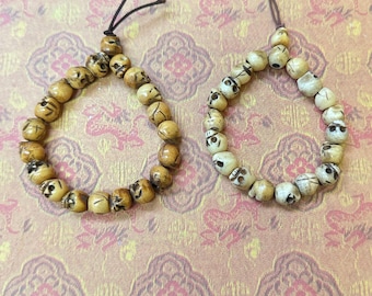 Deux pendentifs en os représentant un bouledogue et un personnage. Les