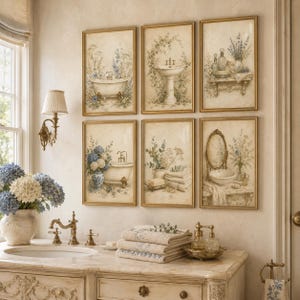 May include: A set of six framed wall art prints featuring vintage-style bathroom illustrations. The prints depict clawfoot bathtubs, pedestal sinks, vanity mirrors, and floral arrangements in soft blue and cream tones, all encased in gold frames.