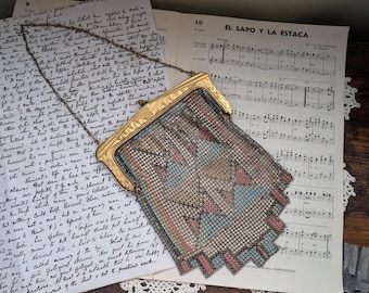 May include: A vintage gold mesh purse with a geometric pattern in shades of blue, pink, and beige. The purse has a chain strap and a clasp closure.