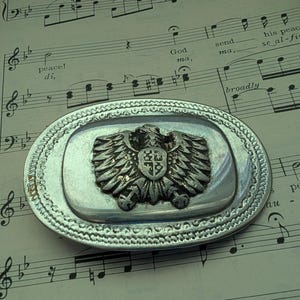 vintage two-tone belt buckle featuring a thunderbird eagle shield crest
