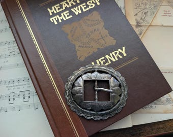 Hebilla de cinturón vintage de plata estilo western con forma de hebilla de cinturón de plata.