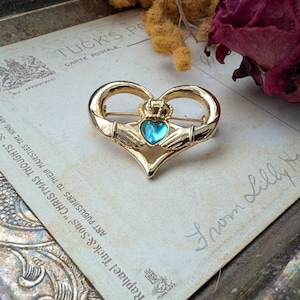 vintage goldtone claddagh brooch with green gemstone