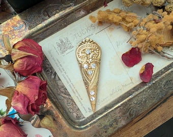 stunning art deco style goldtone brooch with crystal gemstones