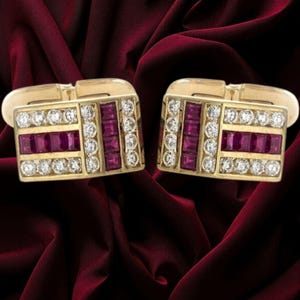 May include: A pair of rectangular gold cufflinks featuring alternating rows of channel-set square rubies and round brilliant-cut diamonds. The design includes a horizontal band of rubies flanked by two rows of diamonds, with a vertical row of rubies.