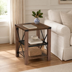 May include: A square end table with a dark wood finish, featuring a black metal X-frame design on the sides. It includes a top surface, a middle shelf with a black metal mesh insert, and a bottom wooden shelf, providing three levels of storage.