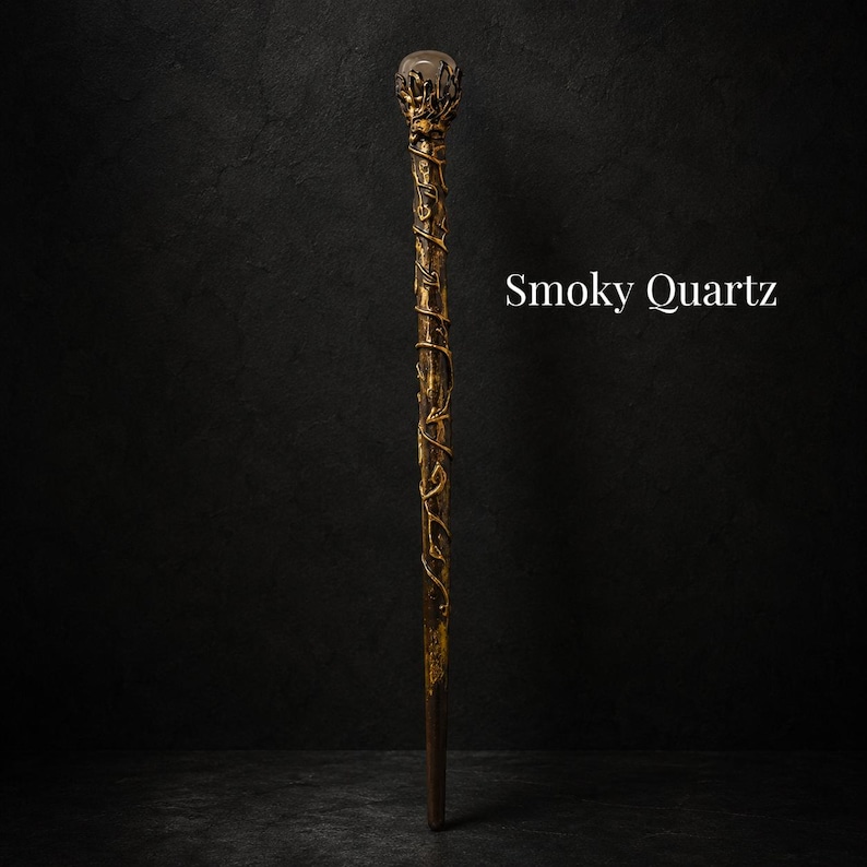 May include: A long, slender wand featuring a dark, textured shaft wrapped in gold-colored vine-like detailing. The top is crowned with a spherical smoky quartz gemstone held by metallic prongs. The text Smoky Quartz is visible to the right.