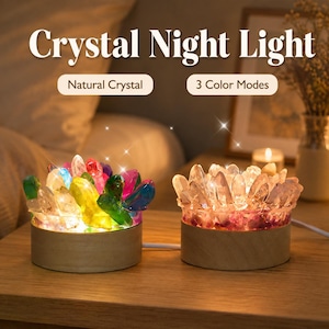 May include: Two crystal night lights with circular wooden bases. The left light features multi-colored crystals, while the right light has clear crystals with a pink base. Text reads: Crystal Night Light, Natural Crystal, 3 Color Modes.