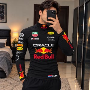 May include: A black long-sleeve mock neck shirt featuring Red Bull racing branding, including the Oracle logo, Red Bull text, and various sponsor logos like TAG Heuer, Mobil 1, Esso, AT&T, ROKT, Pirelli, Rauch, Gate, and Honda, with a small Dutch flag and MAX text.