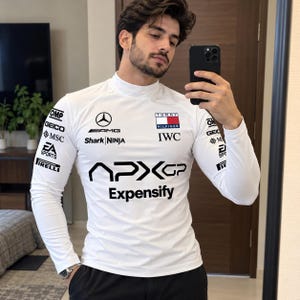May include: A white long-sleeve mock neck shirt featuring various sponsor logos including Mercedes-AMG, Tommy Hilfiger, IWC, Shark Ninja, OMP, GEICO, MSC, EA Sports, Pirelli, APXGP, and Expensify printed in black and color on the chest and sleeves.