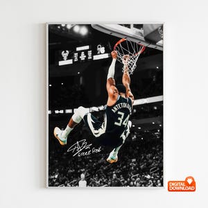 Puede incluir: Un póster deportivo en blanco y negro que muestra a un jugador de baloncesto con una camiseta oscura con el número 34 y el nombre Antetokounmpo, realizando un mate. La imagen incluye una firma y el texto Greek Freak en una cancha.