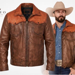 May include: A brown leather jacket with a lighter tan leather yoke, a front zipper closure, two chest pockets with button flaps, and a black quilted interior lining. The logo for Tokyo Leathers Co. is visible in the upper left corner.