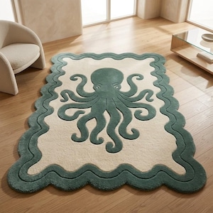 May include: A rectangular area rug featuring a cream-coloured centre with a dark teal octopus graphic. The rug has a thick, wavy dark teal border that follows the scalloped edges of the piece, creating a distinct contrast against the light background.