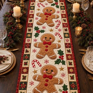 May include: A rectangular quilted table runner featuring a repeating pattern of brown gingerbread people with red bow ties, red candy canes, green holly leaves with red berries, and gold stars on a cream background with a red and green border.
