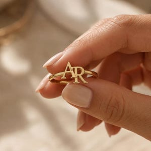 Monogramring, sieraad van 925 sterling zilver met twee initialen en een 14-karaats vergulde afwerking.