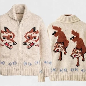Peut inclure: Un gilet zippé en tricot couleur crème avec un col châle et des manches longues. Le devant présente deux motifs de têtes de renard, tandis que le dos montre deux renards entiers. Un motif d'empreintes de pattes bleu clair borde l'ourlet.