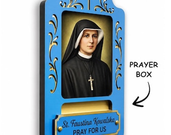 May include: A blue wooden wall plaque featuring a portrait of Saint Faustina Kowalska in a black habit with a cross necklace. The frame has gold filigree cutouts, a cross at the top, and a gold plate with the text St. Faustina Kowalska PRAY FOR US.