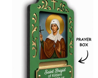 May include: A green wooden wall plaque featuring an icon of Saint Brigid of Kildare with a gold halo. The plaque includes a slot for a prayer box and a gold-coloured metal plate with the text Saint Brigid of Kildare PRAY FOR US.