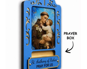 May include: A blue wooden wall-mounted prayer box featuring a central religious print of Saint Anthony of Padua holding the Christ Child. The frame has decorative cutouts, a cross at the top, and a plaque reading St. Anthony of Padua PRAY FOR US.