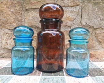 En vintage apoteksburk i blått eller brunt glas med bubbelformat lock, tillverkad i Belgien