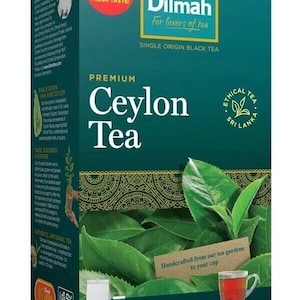 Könnte beinhalten: Eine rechteckige Schachtel Dilmah Premium Ceylon Tee mit fünfzig Teebeuteln. Die blaugrüne Verpackung zeigt das Markenlogo, den Text New Look Same Garden Fresh Taste sowie ein Bild von grünen Teeblättern und einer Tasse Tee.