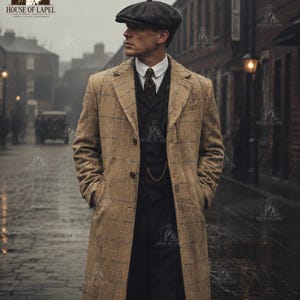 May include: A tan wool overcoat with a blue windowpane check pattern, worn over a dark vest, white collared shirt, and dark tie. The outfit includes a dark flat cap and a gold pocket watch chain attached to the vest, creating a classic ensemble.