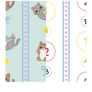 May include: A fabric pattern featuring two distinct vertical sections. The left side is light blue with cartoon cats, yarn balls, yellow stars, and blue ribbons. The right side is white with colorful circles containing numbers and letters.