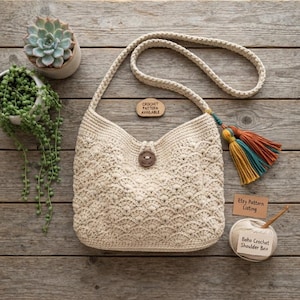 May include: A cream-colored crochet shoulder bag featuring a scalloped pattern, a single wooden button closure, and a multi-colored tassel. A wooden tag reads "CROCHET PATTERN AVAILABLE" and a paper card reads "Etsy Pattern Listing" next to a ball of yarn.