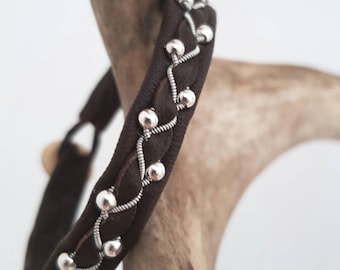 Pode incluir: Um bracelete de couro castanho com contas prateadas tecidas no design.